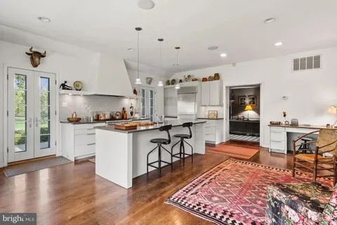 a kitchen with a refrigerator a stove and a fireplace with wooden floor