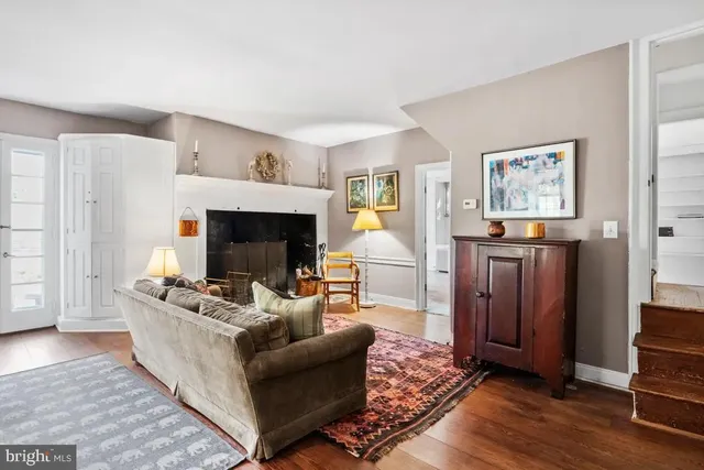 a view of a yard in front of a house with plants and large tree