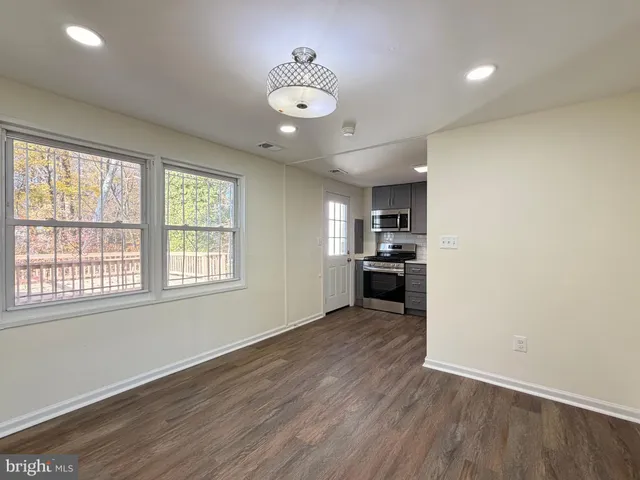 wooden floor in an empty room with a kitchen
