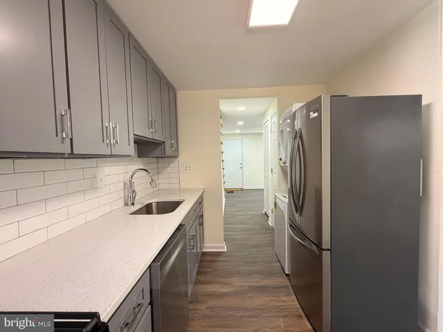 a kitchen with a sink a refrigerator and cabinets