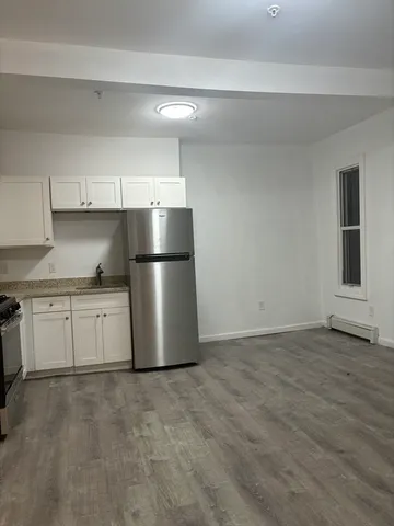 a kitchen with a refrigerator and white cabinets
