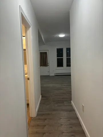 a view of hallway with wooden floor and stairs