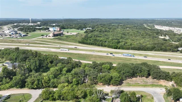 an aerial view of residential houses with outdoor space and trees