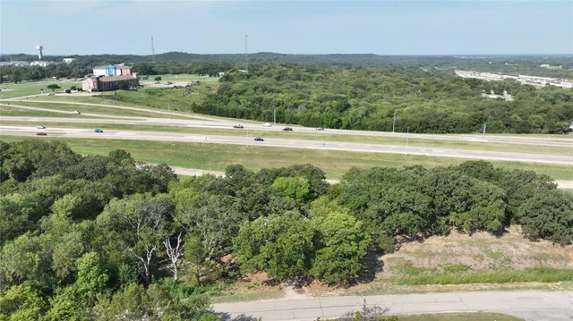 an aerial view of residential houses with outdoor space and trees
