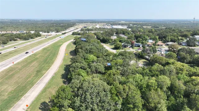 an aerial view of residential houses with outdoor space and trees