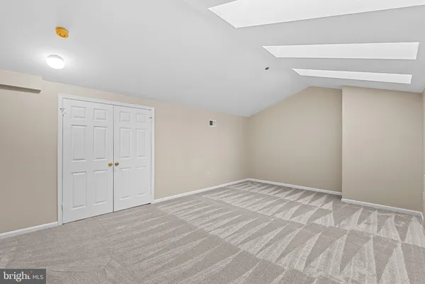 an empty room with windows and fireplace