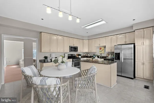 a kitchen with granite countertop white cabinets and stainless steel appliances