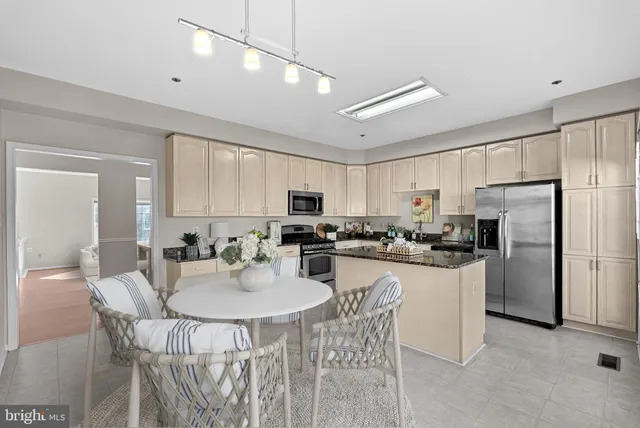 a kitchen with granite countertop white cabinets and stainless steel appliances
