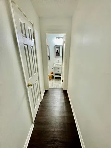 a view of a hallway with wooden floor and staircase