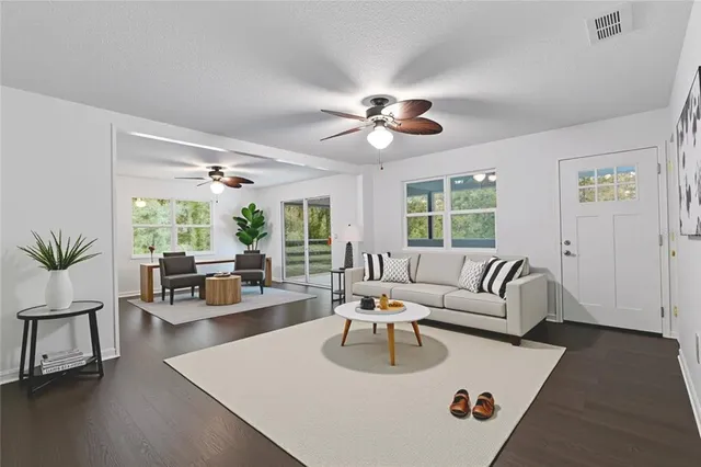 a living room with furniture wooden floor and a large window