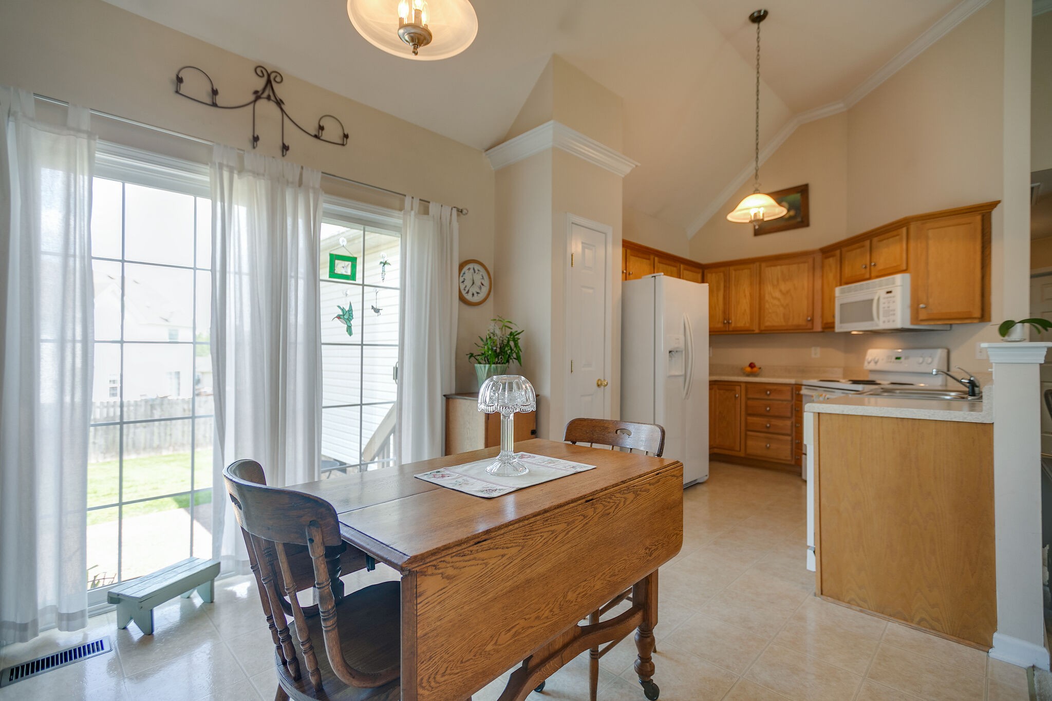 1003 Patterson Street Spring Hill, TN 37174 - Photo 10 of 27 a dining room with stainless steel appliances granite countertop a stove a sink dishwasher a dining table and chairs with wooden floor