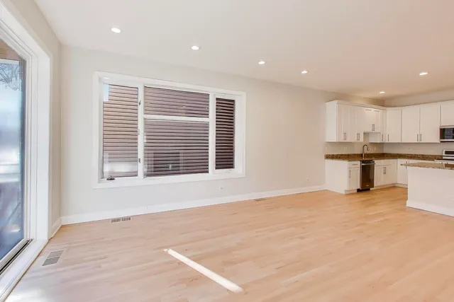 a spacious bedroom with a bed and a dresser