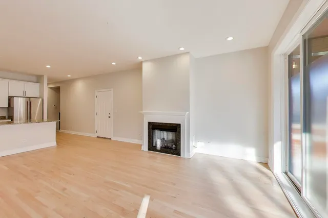 an empty room with wooden floor and fireplace