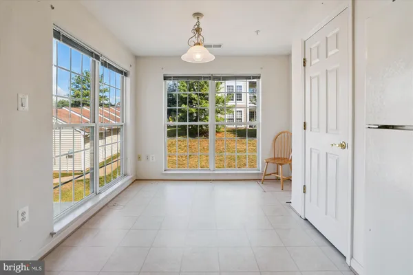 an empty room with window and ceiling fan