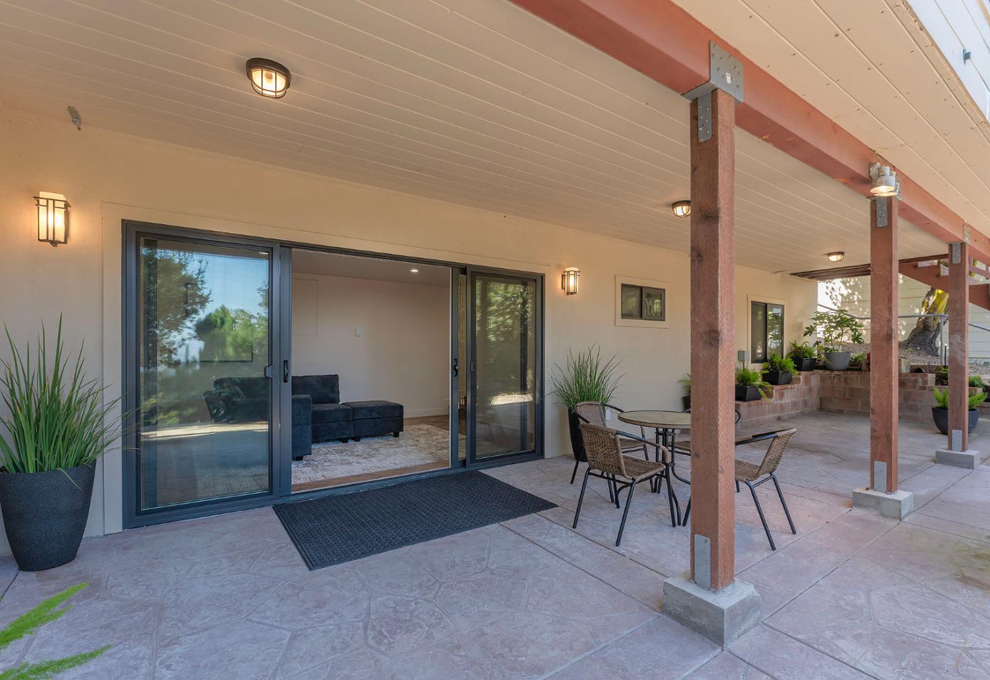 a view of a patio with a table and chairs and potted plants