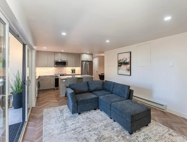 a living room with furniture and a kitchen view