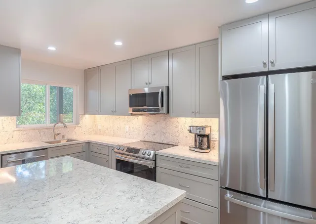 a kitchen with stainless steel appliances a refrigerator sink and microwave