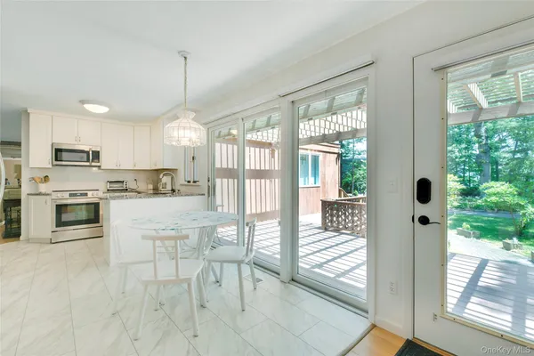 a kitchen with stainless steel appliances granite countertop a stove top oven a sink with a dining table and chairs