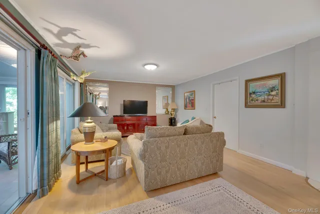 a living room with furniture a large window and a flat screen tv