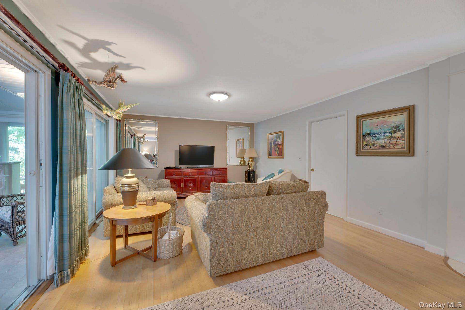 1075 Inlet Lane Greenport, NY 11944 - Photo 6 of 30 a living room with furniture a large window and a flat screen tv