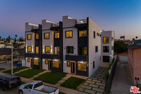 a front view of a residential apartment building with a yard