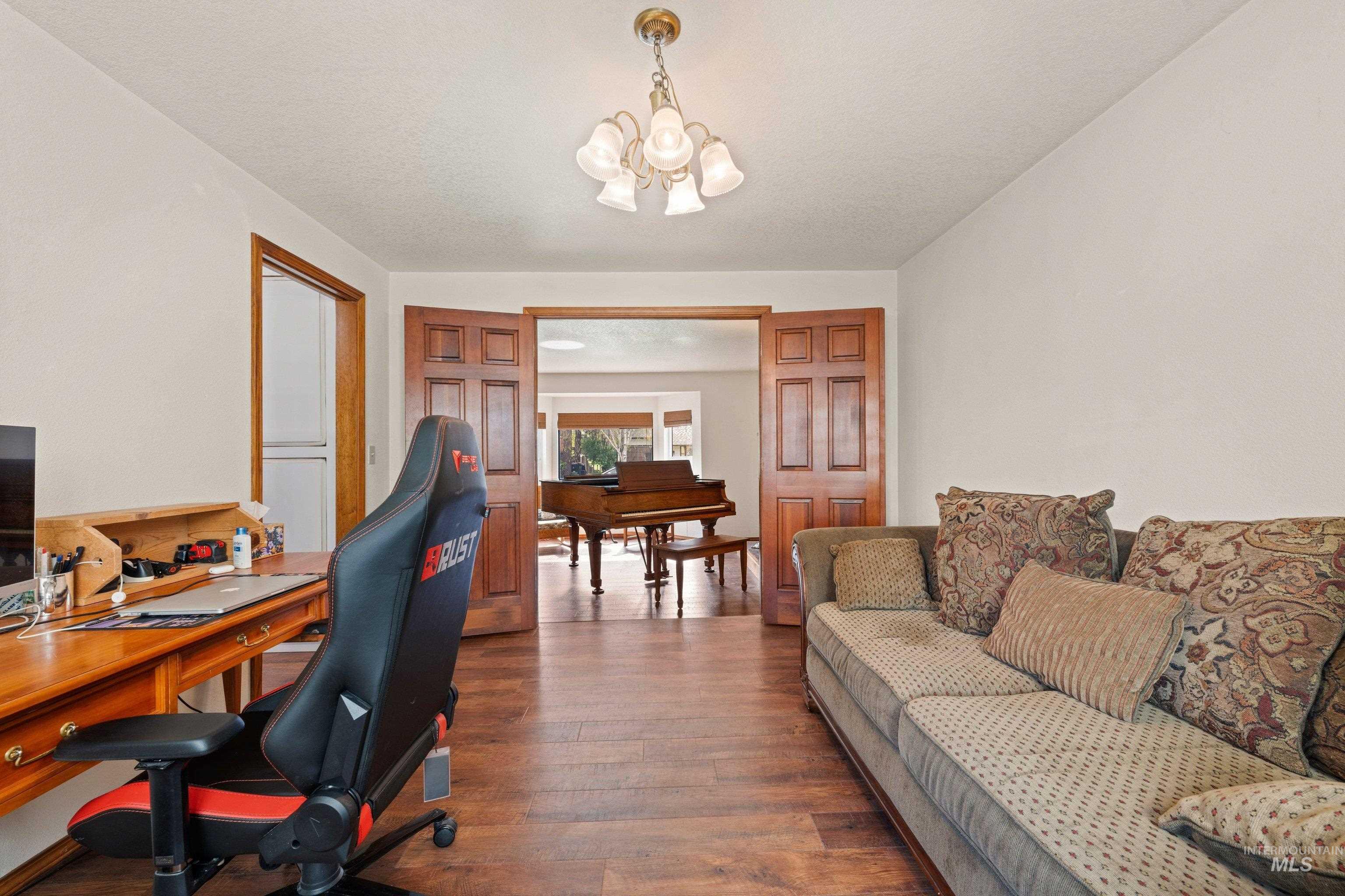 1921 Incline Way Meridian, ID 83646 - Photo 41 of 50 Spacious room featuring wood-finish flooring, a ceiling-mounted chandelier, and paneled French doors opening to an additional room