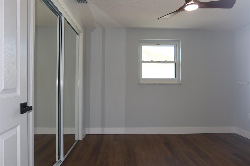 7521 Coventry Drive Port Richey, FL 34668 - Photo 22 of 45 an empty room with wooden floor closet and windows