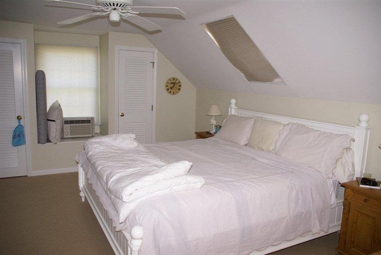 39 Pine Grove Road Chatham, MA 02633 - Photo 27 of 34 a bedroom with a large bed and a chandelier