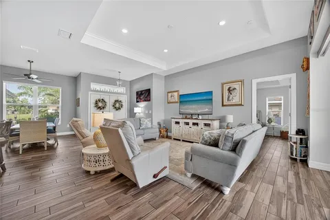 a kitchen with stainless steel appliances a white refrigerator a microwave a stove and white cabinets with wooden floor