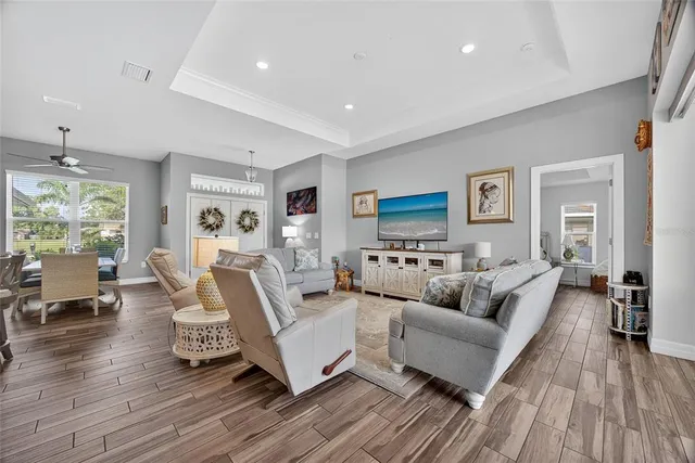 a kitchen with stainless steel appliances a white refrigerator a microwave a stove and white cabinets with wooden floor