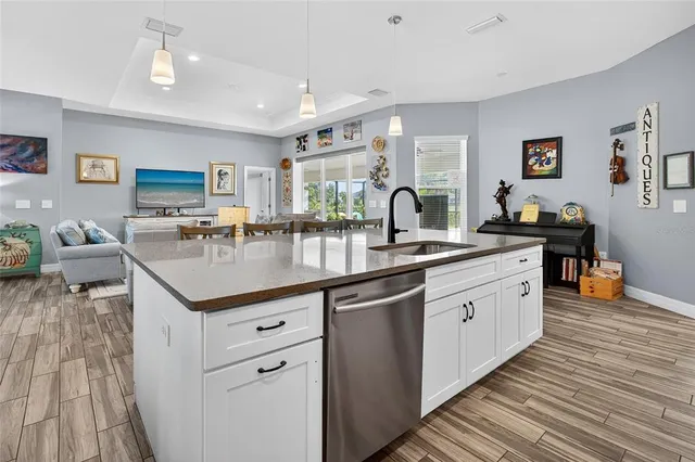 a kitchen with stainless steel appliances a dining table chairs stove refrigerator and cabinets