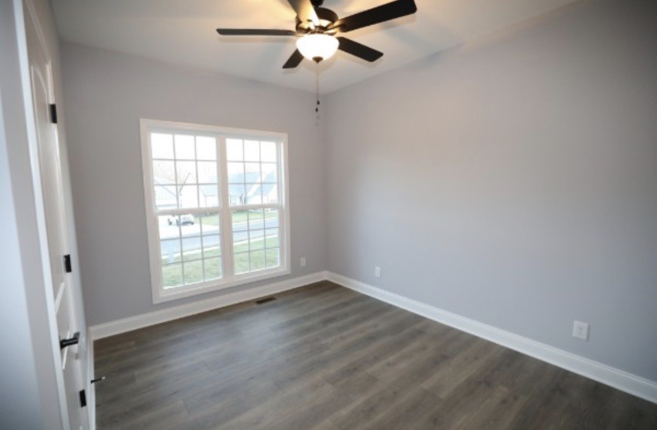 7246 Winding Way Pleasant View, TN 37146 - Photo 16 of 24 an empty room with wooden floor fan and windows