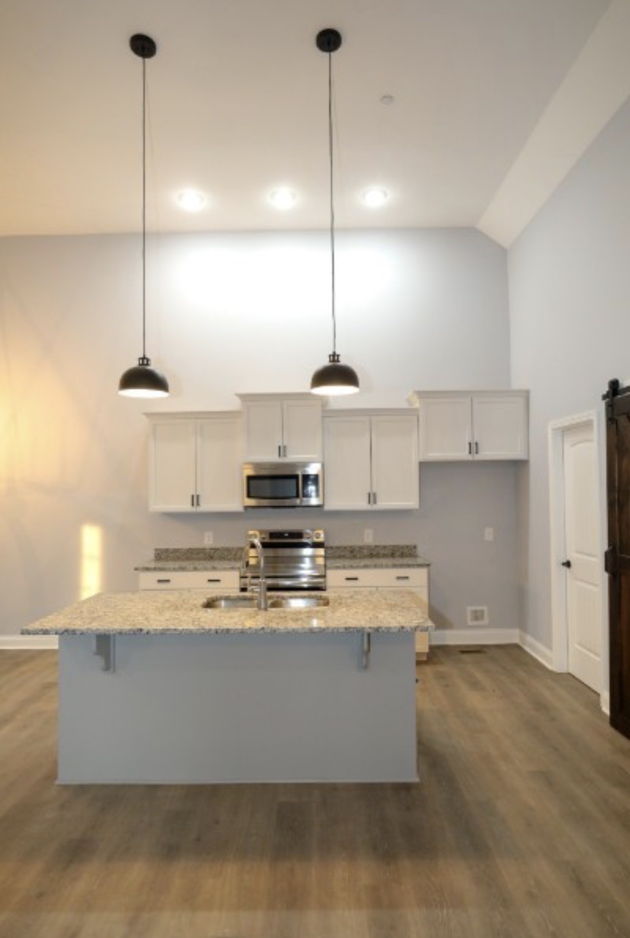 7246 Winding Way Pleasant View, TN 37146 - Photo 6 of 24 a kitchen with kitchen island stainless steel appliances a stove a sink and a wooden floor