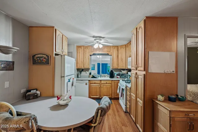 a kitchen with sink refrigerator dining table and chairs