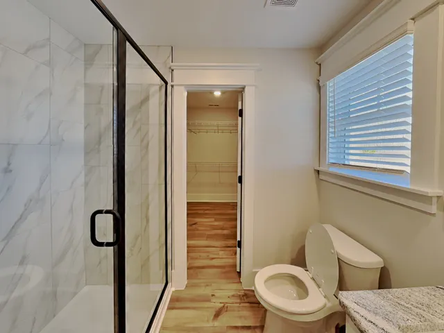 a bathroom with a toilet and a shower