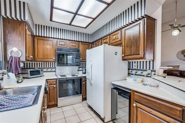 a kitchen with kitchen island a sink stove and refrigerator