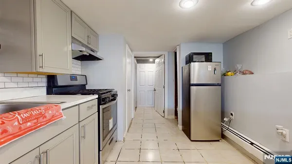 a kitchen with a refrigerator a stove top oven and cabinets