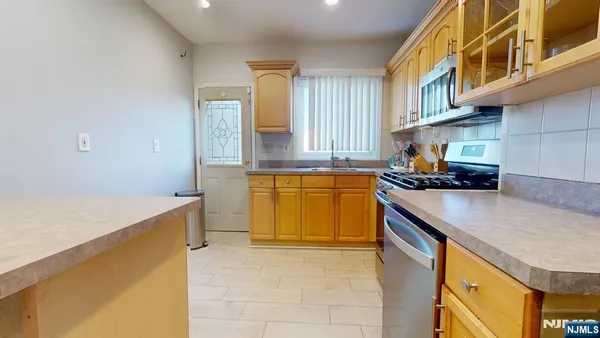 a kitchen with stainless steel appliances granite countertop a sink and a stove