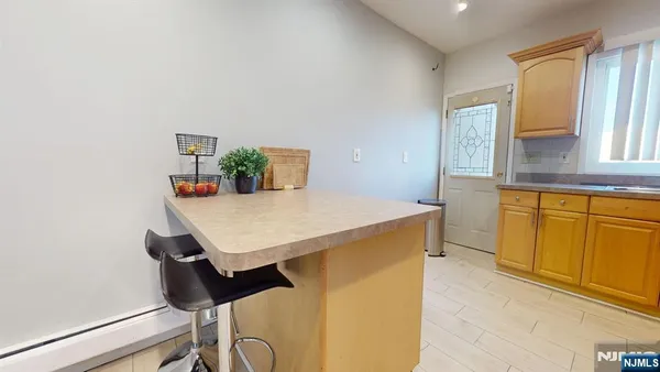 a living room with table chairs and a refrigerator