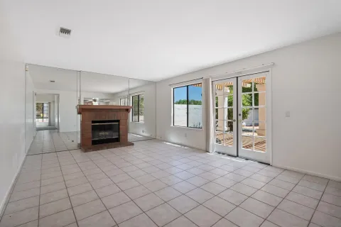 a view of an empty room with a fireplace and a window