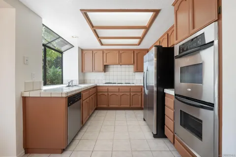 a kitchen with stainless steel appliances granite countertop a stove a sink and a refrigerator