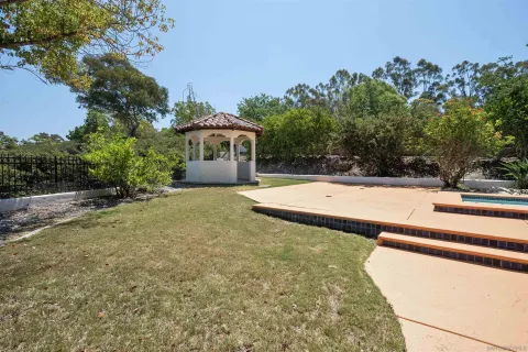 a view of a white house next to a yard