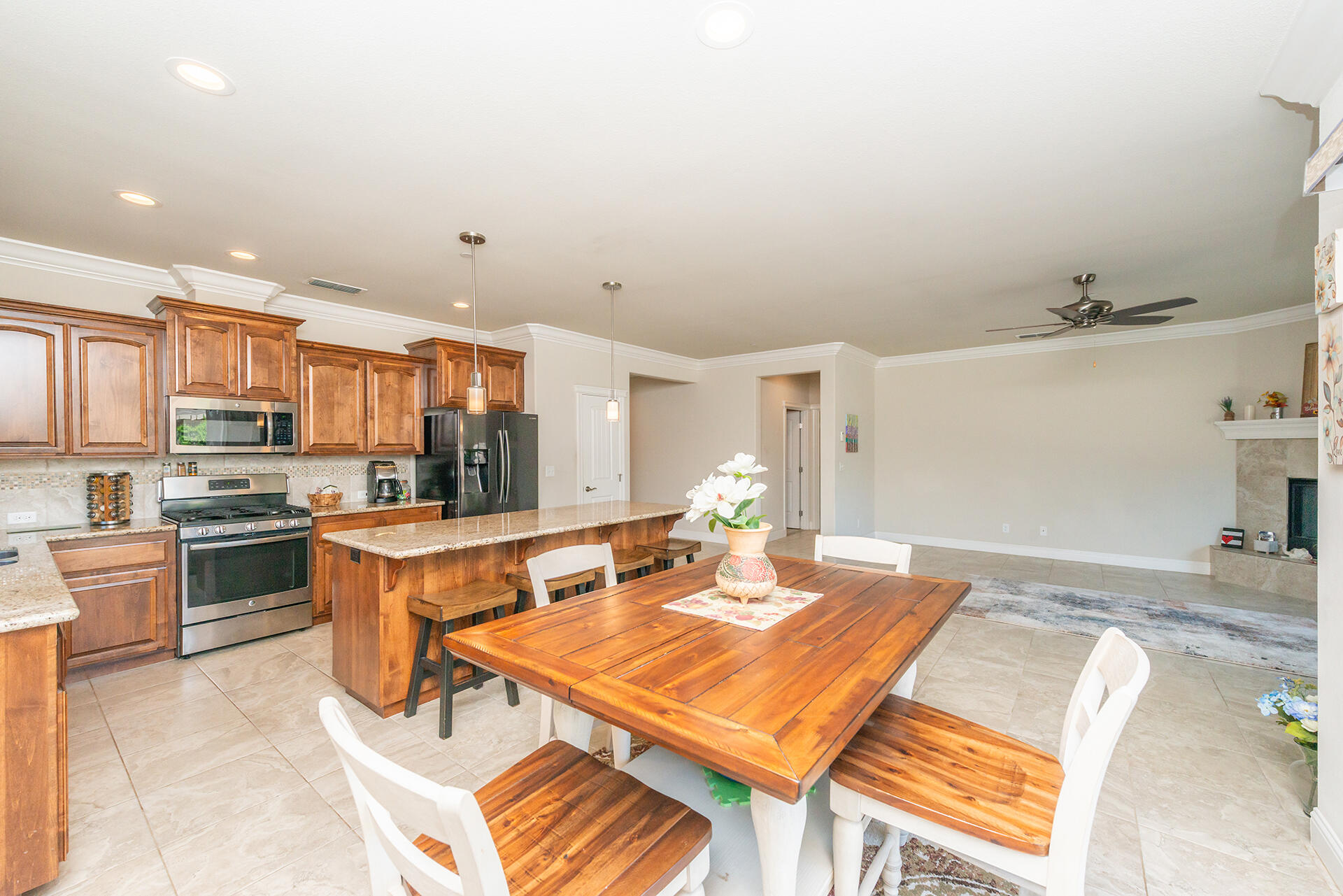 3326 Hotlam Road Redding, CA 96002 - Photo 23 of 60 a kitchen with stainless steel appliances kitchen island granite countertop a refrigerator a stove a sink a dining table and chairs with wooden floor