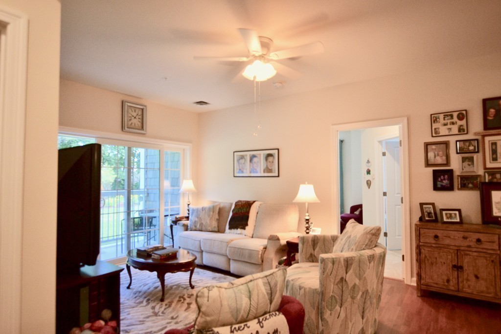 7 Augustus Court, Unit 1013 Reading, MA 01867 - Photo 14 of 34 a living room with furniture a flat screen tv and a large window