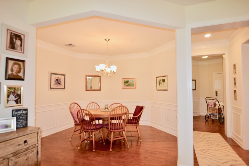 7 Augustus Court, Unit 1013 Reading, MA 01867 - Photo 16 of 34 a view of a dining room with furniture and wooden floor