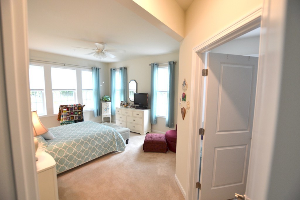 7 Augustus Court, Unit 1013 Reading, MA 01867 - Photo 18 of 34 a bedroom with a bed and large mirror in it