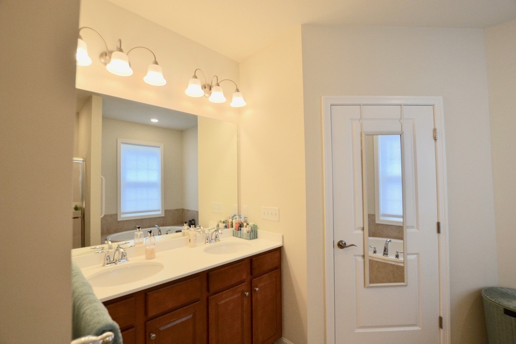 7 Augustus Court, Unit 1013 Reading, MA 01867 - Photo 21 of 34 a bathroom with a double vanity sink and a mirror