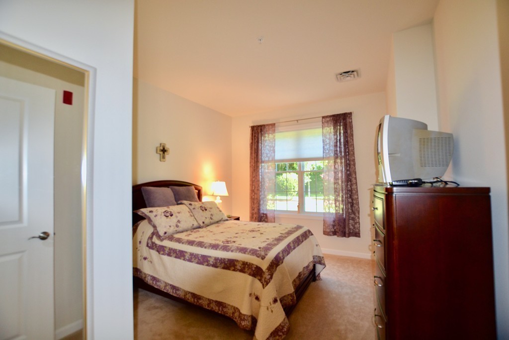 7 Augustus Court, Unit 1013 Reading, MA 01867 - Photo 23 of 34 a bedroom with a bed and a window