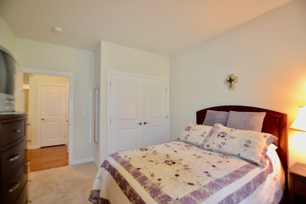 7 Augustus Court, Unit 1013 Reading, MA 01867 - Photo 24 of 34 a bedroom with a bed and a cabinets