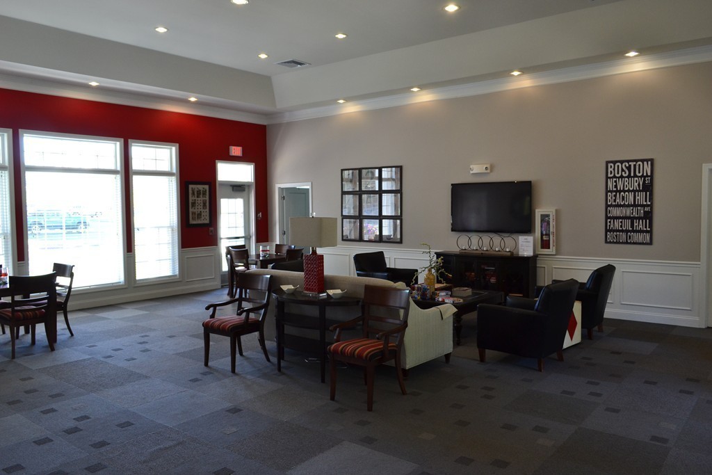 7 Augustus Court, Unit 1013 Reading, MA 01867 - Photo 32 of 34 a living room with furniture a large window and a flat screen tv